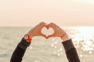 手でハートマークを作る女性